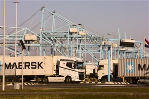 Containers being transferred onto trucks in the port of Rotterdam.