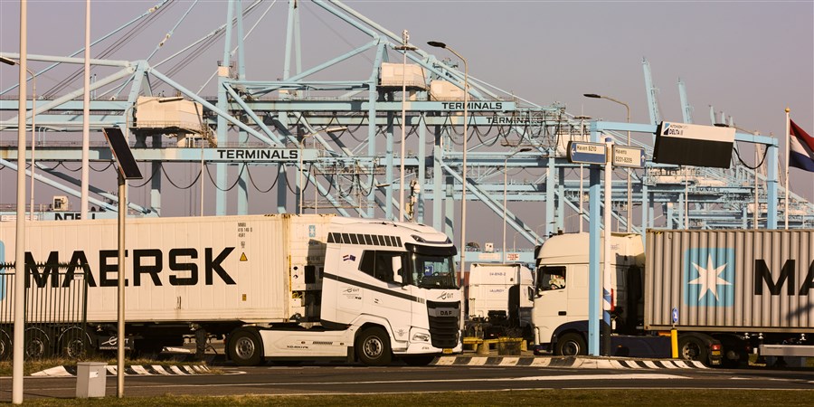 Containers being transferred onto trucks in the port of Rotterdam.