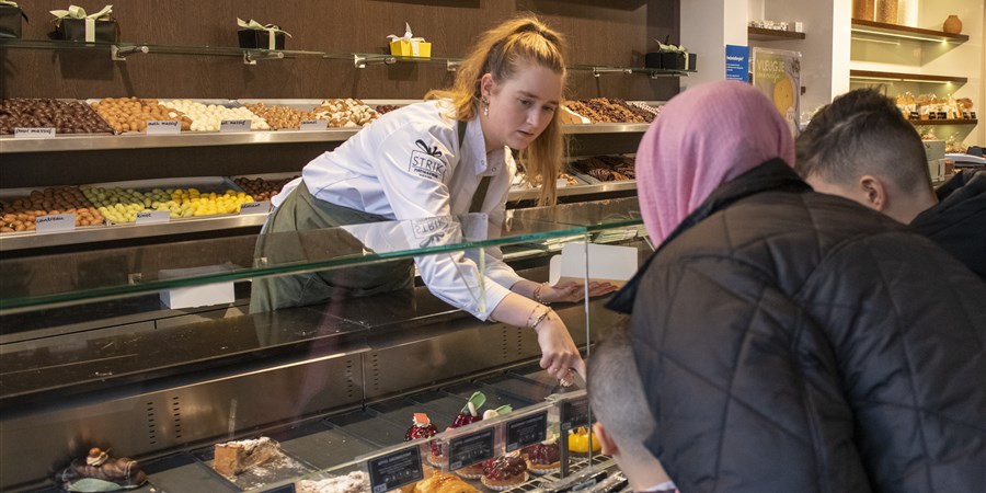 Verkoopmedewerker banketbakkerij aan het werk in de winkel.