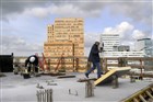 Twee bouwvakkers aan het werk op een gebouw aan de Amsterdamse Zuidas