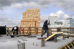 Twee bouwvakkers aan het werk op een gebouw aan de Amsterdamse Zuidas