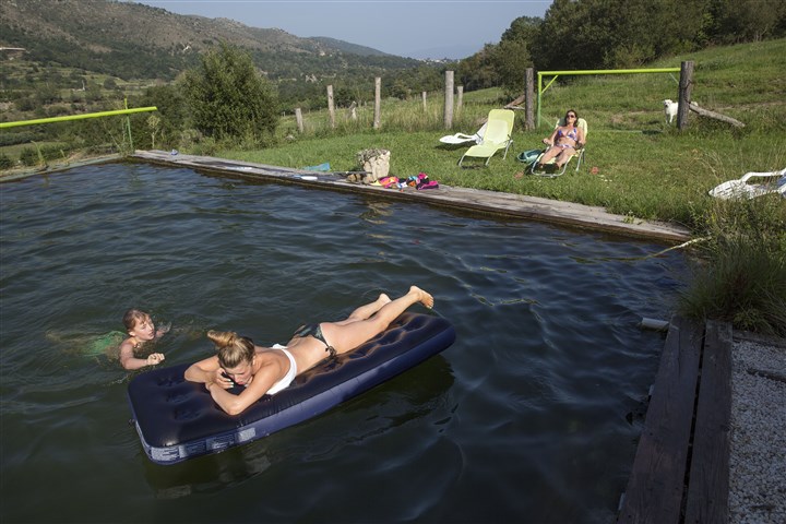 Kinderen vermaken zich in het privé natuurzwembad, wat gevuld is met water uit de bron.