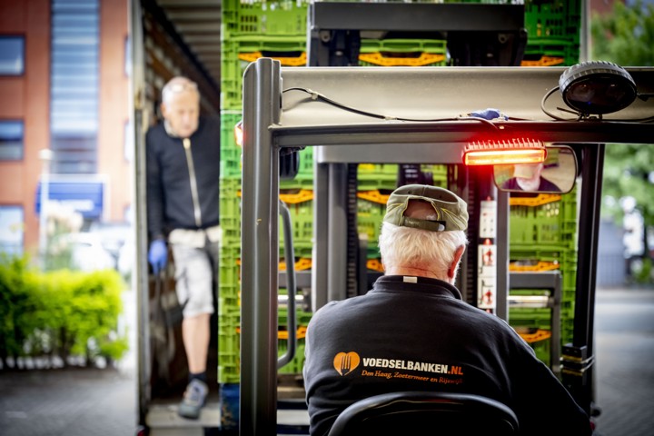 Vrijwilligers van de voedselbank in den haag zijn voedselpakketten aan het inladen.