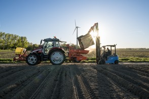 Akkerbouwer is bezig met het planten van pootaardappelen