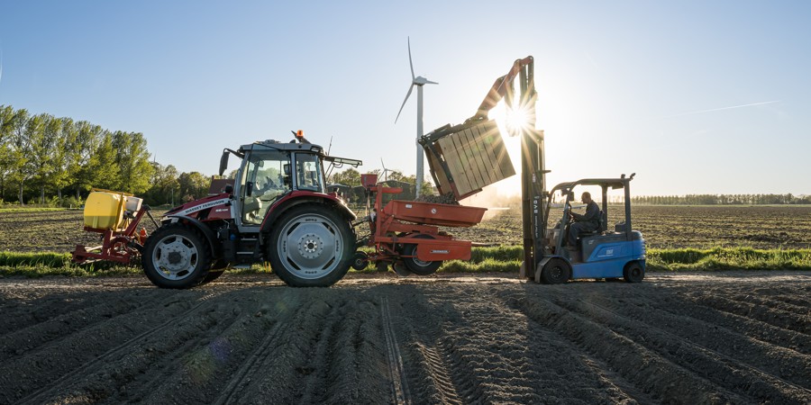 Akkerbouwer is bezig met het planten van pootaardappelen