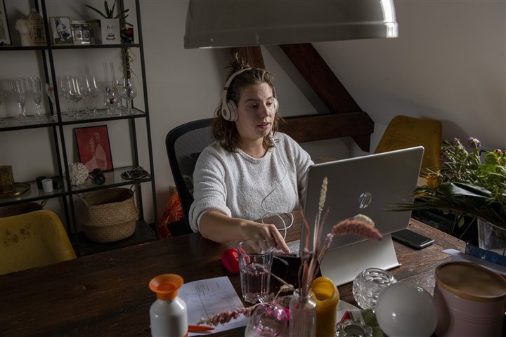 A woman working at a laptop in a domestic setting