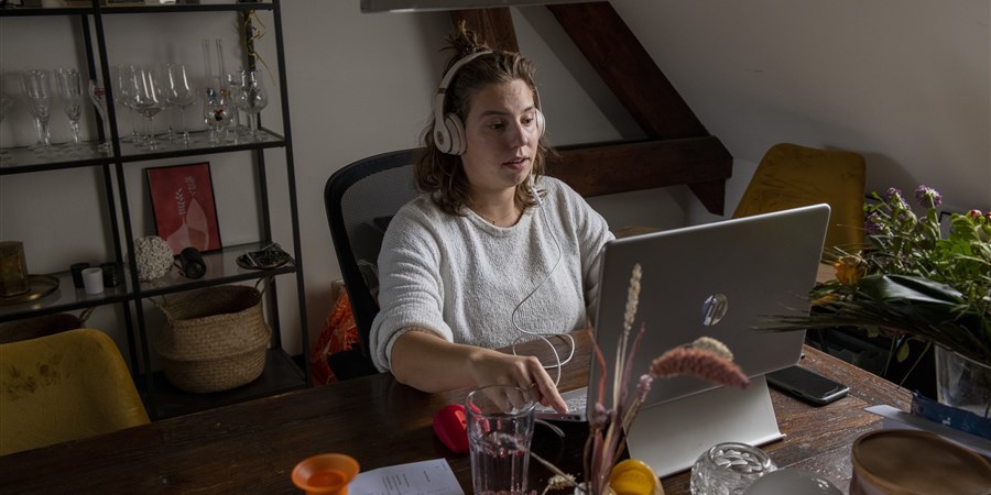 Nederland, Nijmegen, 12-10-2022 - Jonge vrouw werkt thuis op haar laptop. foto: ANP / Hollandse Hoogte / Patricia Rehe