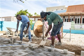 Two construction workers pave a road on Bonaire