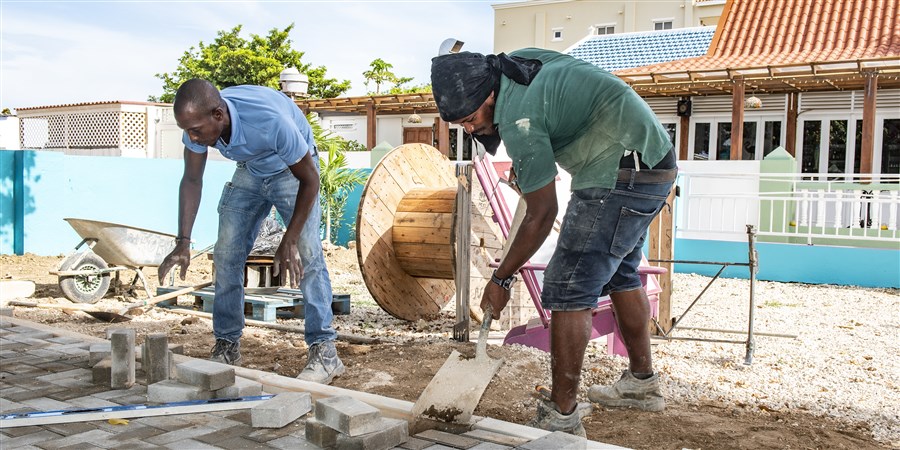 Twee bouwvakkers bestraten een weg op Bonaire