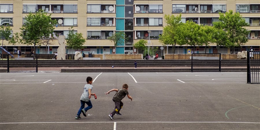 Voetballende jongens op een speelplein