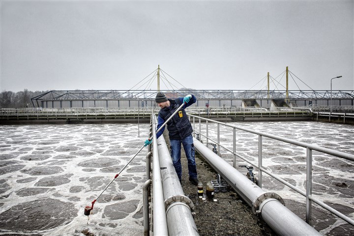 Medewerker van Waterschap de Dommel neemt monsters van het Tilburgs afvalwater dat is binnen gekomen bij de rioolwaterzuivering in Tilburg-Noord.