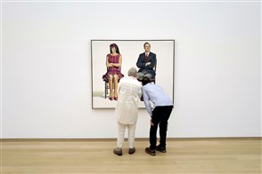 twee bezoekers van een museum bekijken een schilderij