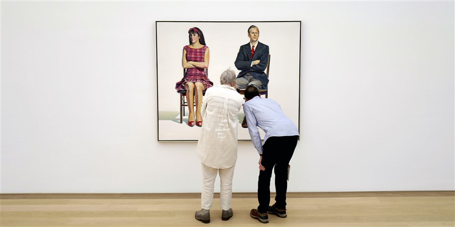 twee bezoekers van een museum bekijken een schilderij