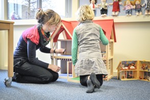 Kind en begeleider aan het spelen in de opvang