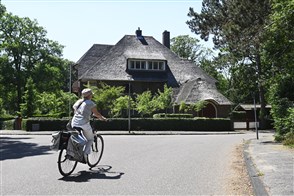 Fietster rijdt door een dure villawijk van Heemstede.