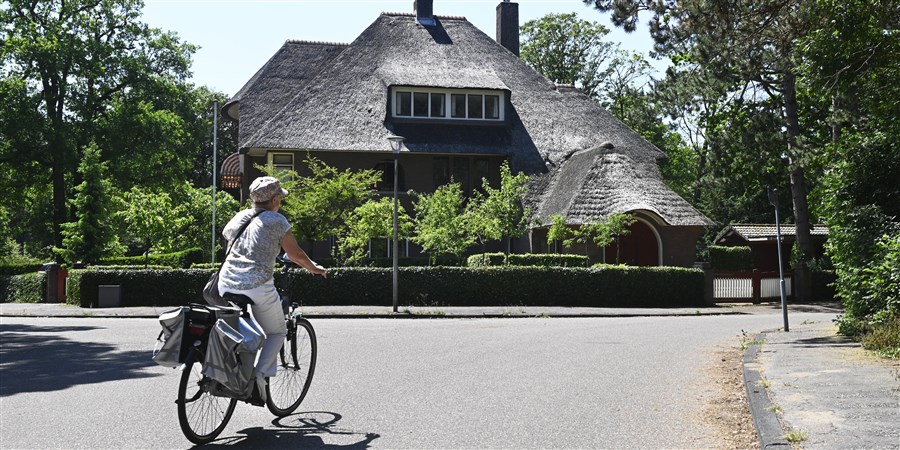 Fietster rijdt door een dure villawijk van Heemstede.