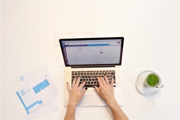 Hands of a person working on a laptop