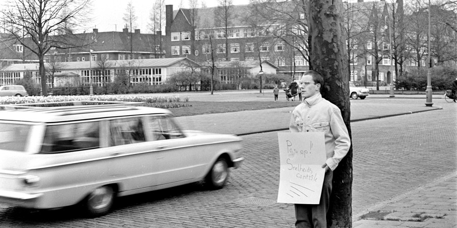 Man met bord ‘‘Pas op Snelheidscontrole’’, 14 april 1966