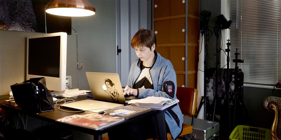 Vrouw werkt thuis in de studeerkamer aan haar laptop.