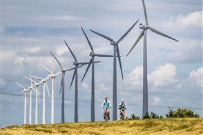 Cyclists in front of wind turbines