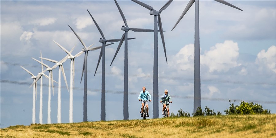 Cyclists in front of wind turbines