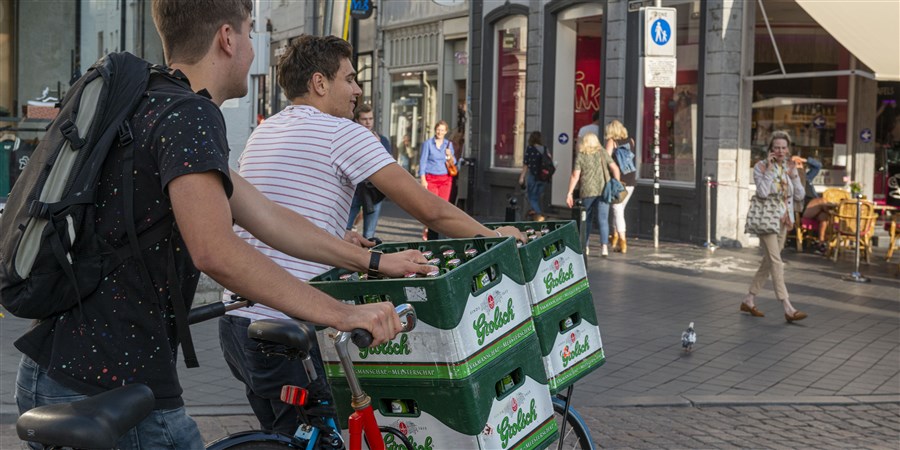 Twee jongens vervoeren in Maastricht bierkratjes op de swappfiets