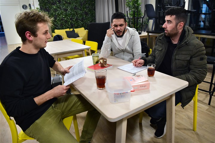 Student geeft les aan statushouders in de Nederlandse taal