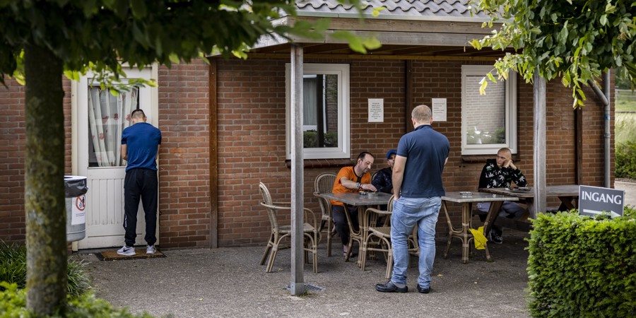 Poolse arbeidsmigranten zitten buiten met elkaar te kletsen bij hotel de Uitkijk.>>
