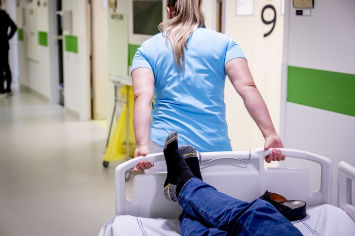 Spoedeisendehulp in een ziekenhuis. Ziekenhuispersoneel rijdt bed met patient door een ziekenhuisgang