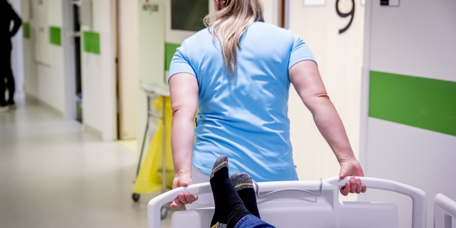 Spoedeisendehulp in een ziekenhuis. Ziekenhuispersoneel rijdt bed met patient door een ziekenhuisgang