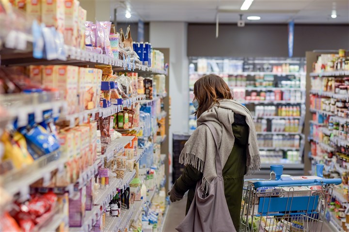 Vrouw doet boodschappen in een supermarkt met een boodschappenkar