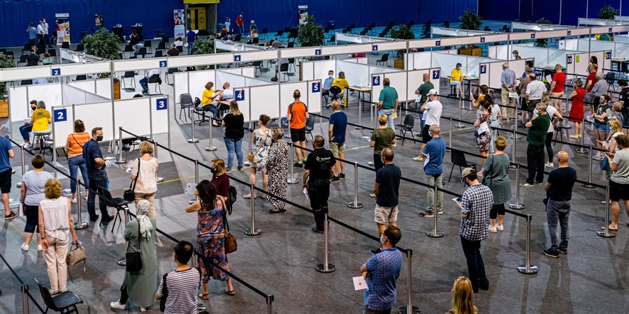 People wait in lines to be vaccinated at a GGD vaccination site.