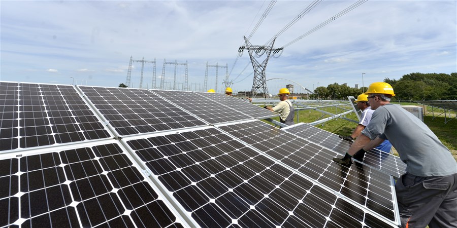 Op het terrein van de kolengestookte elektriciteitscentrale van gdf-suez wordt een veld vol zonnepanelen geplaatst en vormt een energiecentrale die stroom opwekt.