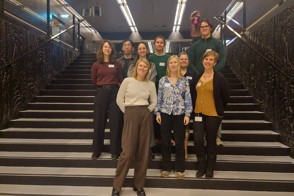 PhD-studenten uit Nederland en België staan op de trap in de Universiteitsbibliotheek van het Utrecht Science Park