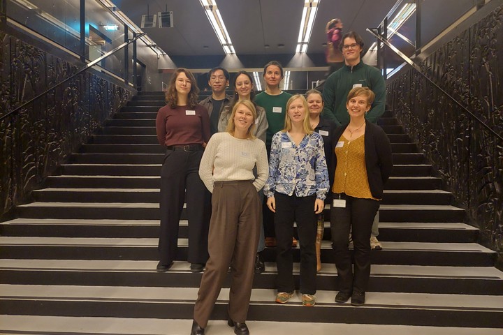 PhD-studenten uit Nederland en België staan op de trap in de Universiteitsbibliotheek van het Utrecht Science Park