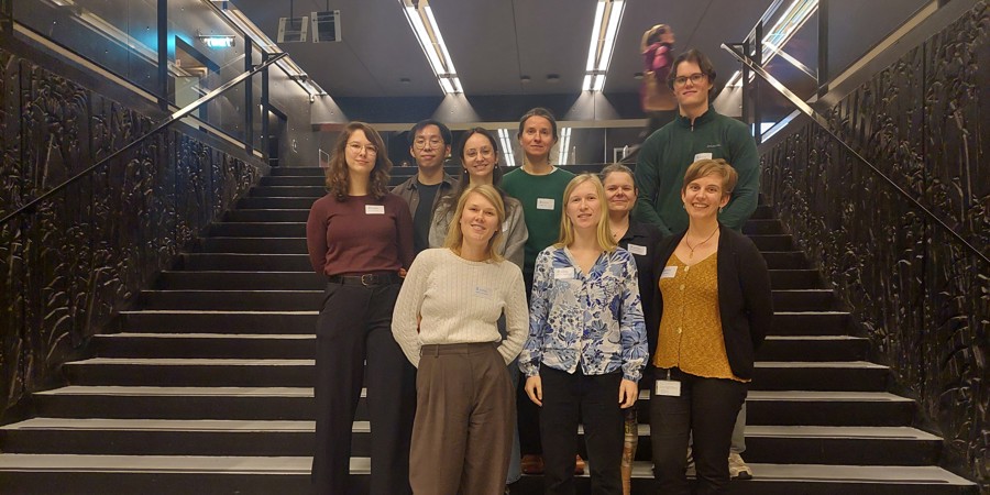 PhD-studenten uit Nederland en België staan op de trap in de Universiteitsbibliotheek van het Utrecht Science Park