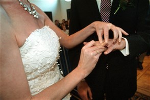 Bride puts ring on groom&#x27;s finger