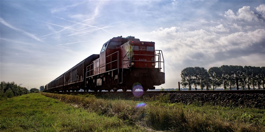 Een locomotief rijdt over het spoor door de natuur