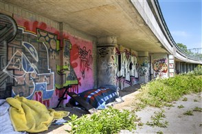 Keurig opgemaakt bed van een dakloos persoon onder spoorviaduct in Rotterdam Delfshaven