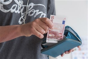 Vrouw houdt portemonnaie met 10 eurobriefje vast