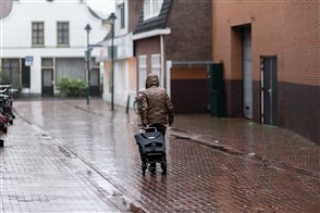 Man alleen in regenachtige straat