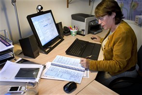 Een vrouw werkt thuis aan de computer