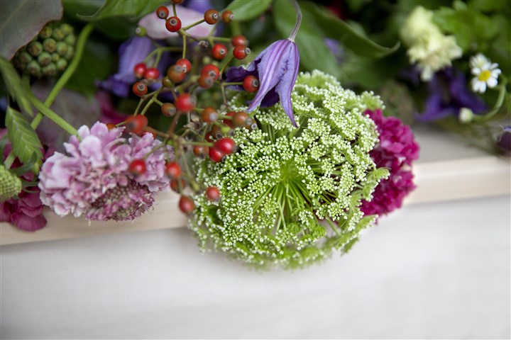 Flower arrangement is on the coffin of a recently deceased person