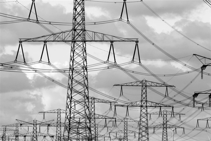 Grote hoeveelheid hoogspanningsmasten tegen een achtergrond van wolken