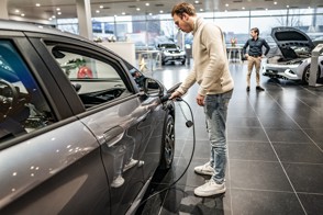 Twee verkopers in een showroom met elektrische auto’s.