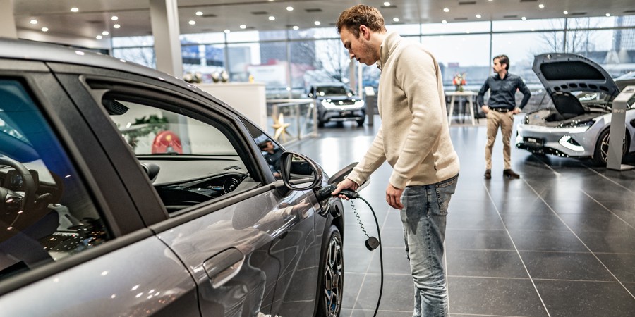 Twee verkopers in een showroom met elektrische auto’s.
