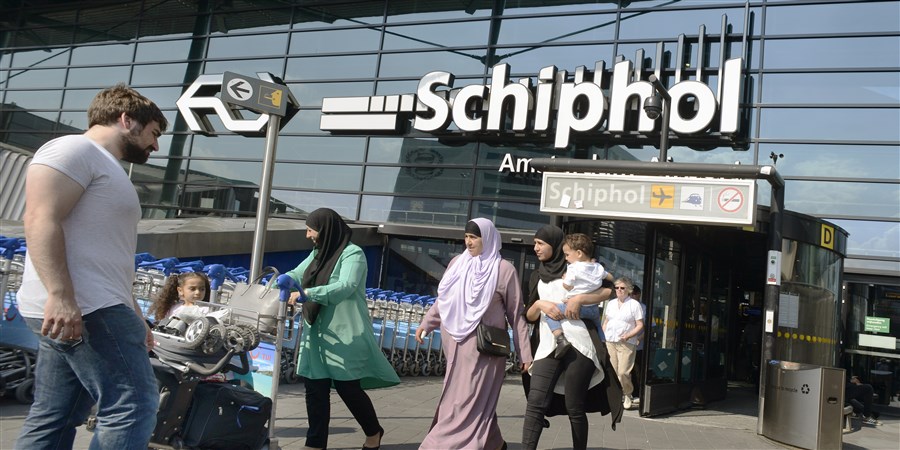 Turkse vrouwen verlaten het stationsgebouw van Schiphol.