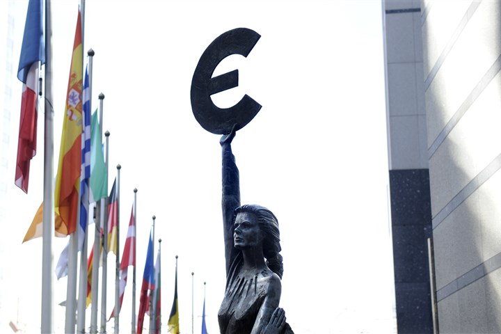 Standbeeld voor gebouw Europese bank persoon houdt euroteken omhoog