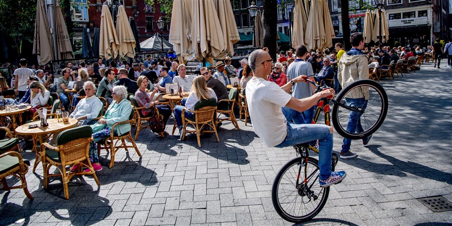 Mensen genieten op een terras in Amsterdam
