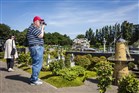 Een Amerikaanse toerist fotografeert een miniatuurmolen tijdens een bezoek aan Madurodam
